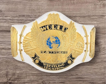 May include: A white and gold wrestling championship belt with the words "WORLD HEAVYWEIGHT WRESTLING CHAMPION" displayed. The belt features a gold eagle design with a blue globe in the center.