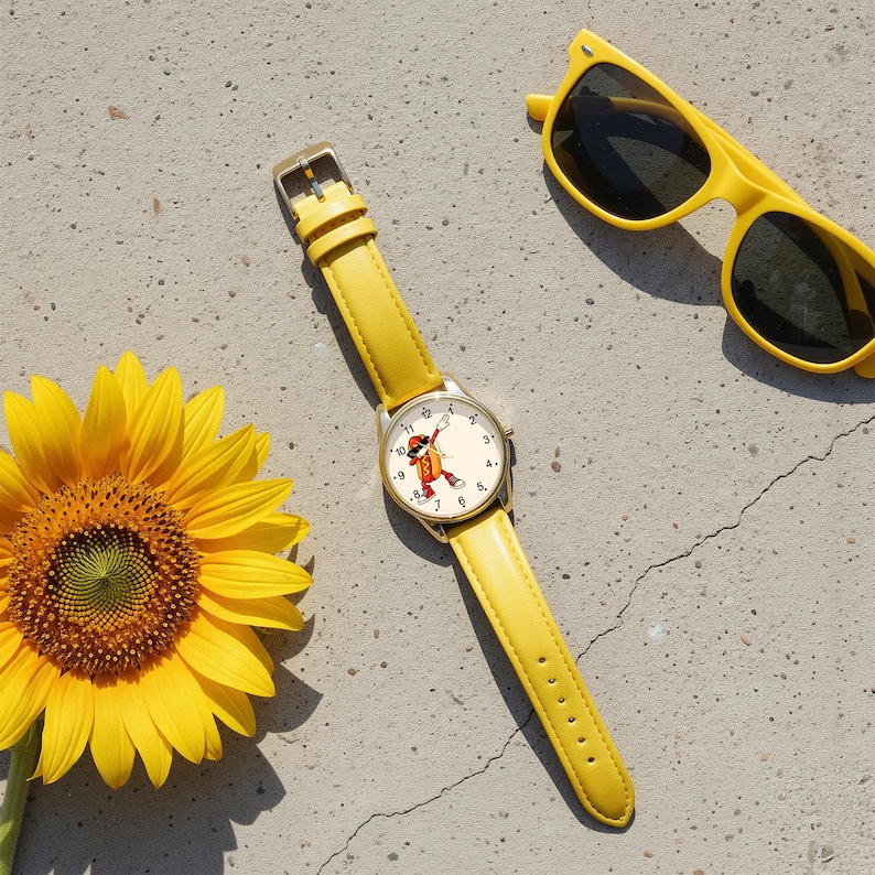 May include: A yellow wristwatch with a round face featuring a cartoon hot dog character dabbing, paired with a bright yellow sunflower and yellow-framed sunglasses. The watch has a smooth yellow leather strap and a gold-tone metal watch case.