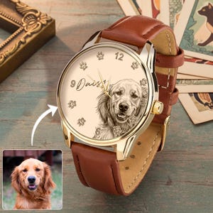 Pu&ograve; includere: Orologio da polso color oro con cinturino in pelle marrone. Il quadrante dell'orologio presenta un'incisione dettagliata di un Golden Retriever, impronte di zampe e il nome "Daisy". L'orologio ha lancette dorate e una lunetta dorata.