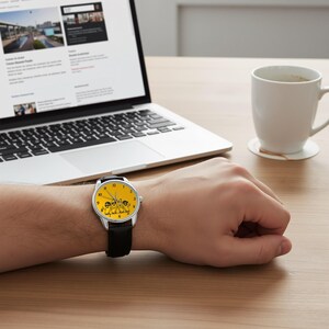 Puede incluir: Un reloj de pulsera con caja circular plateada y correa de cuero negra. La esfera es de color amarillo brillante y presenta una ilustraci&oacute;n gr&aacute;fica negra de tres personajes de dibujos animados con gafas de sol, con n&uacute;meros y agujas negros.