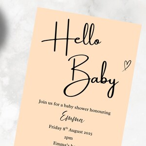 May include: A peach-colored baby shower invitation with black script that reads "Hello Baby." The invitation includes details for a baby shower honoring Emma on August 8th, 2025, at 2 pm at Emma's house.