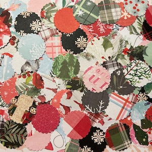 May include: A collection of scalloped-edge paper cutouts with various holiday-themed patterns. Designs include plaid, snowflakes, Christmas trees, and floral arrangements in red, green, black, and white. Some cutouts have text.