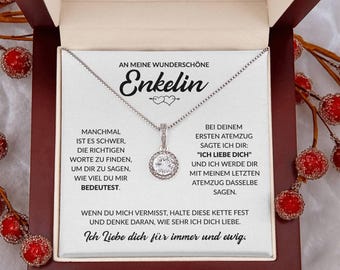 May include: A silver necklace with a round, clear pendant, presented in a wooden box. The box contains a card with German text, including the word "Enkelin" and the phrase "Ich liebe dich für immer und ewig."