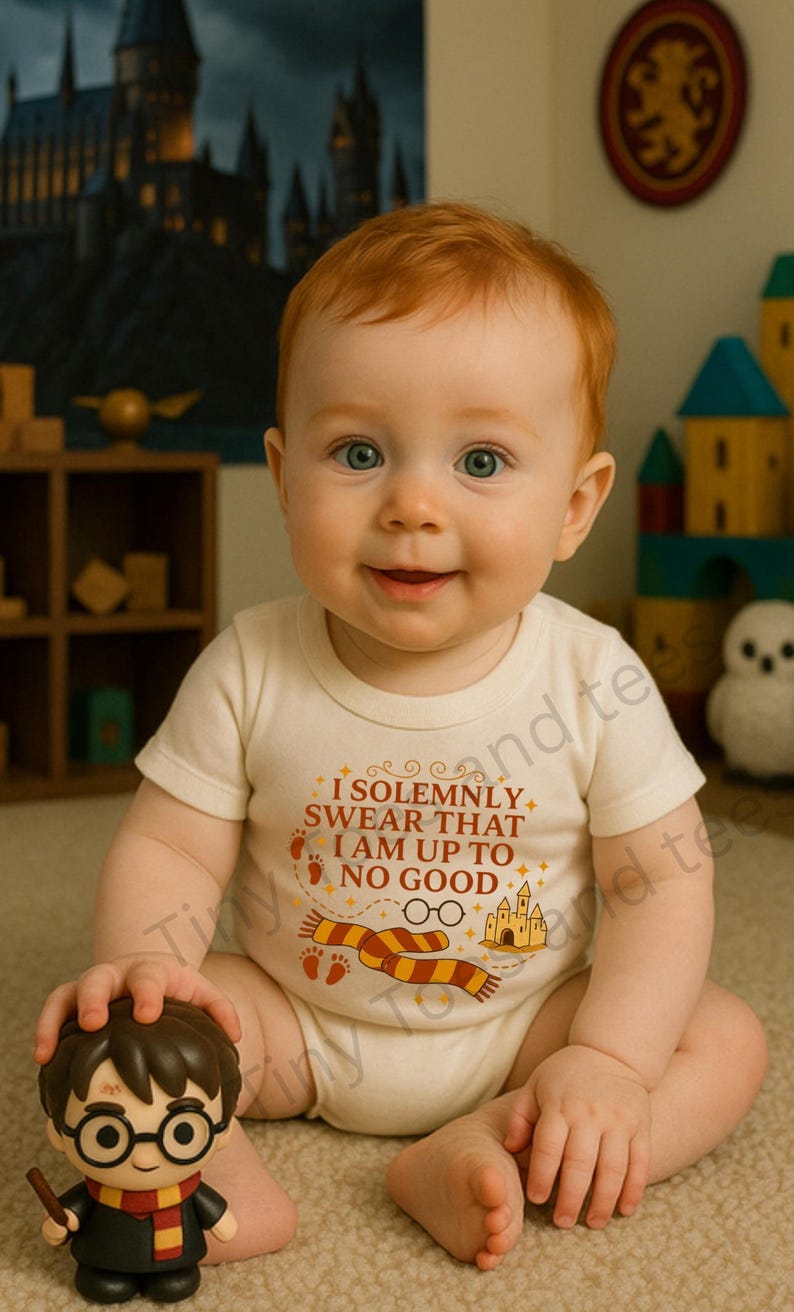 May include: A baby wearing a cream-colored onesie with the text "I Solemnly Swear That I Am Up To No Good" and a Harry Potter-themed graphic. The baby is holding a Harry Potter figurine. The background includes a castle painting and wooden toys.