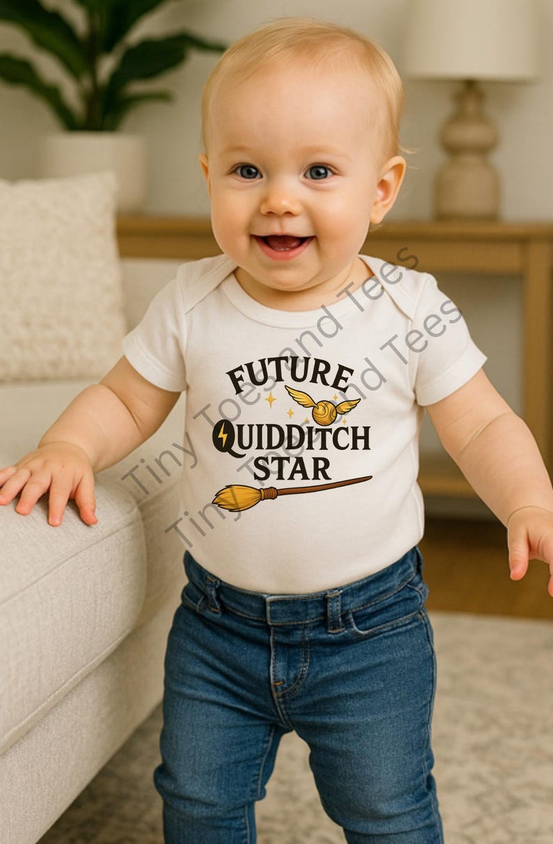 May include: A smiling baby wearing a white onesie with the words "Future Quidditch Star" and a golden snitch and broom graphic. The baby is also wearing blue jeans.