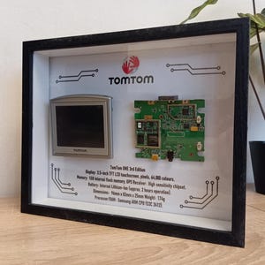 Zerlegtes Navigationsgerät TomTom One im Rahmen, Teardown-Schattenbox, Diorama, Wandkunst, dekonstruierte Kunst. Recyceltes Tech Dekor