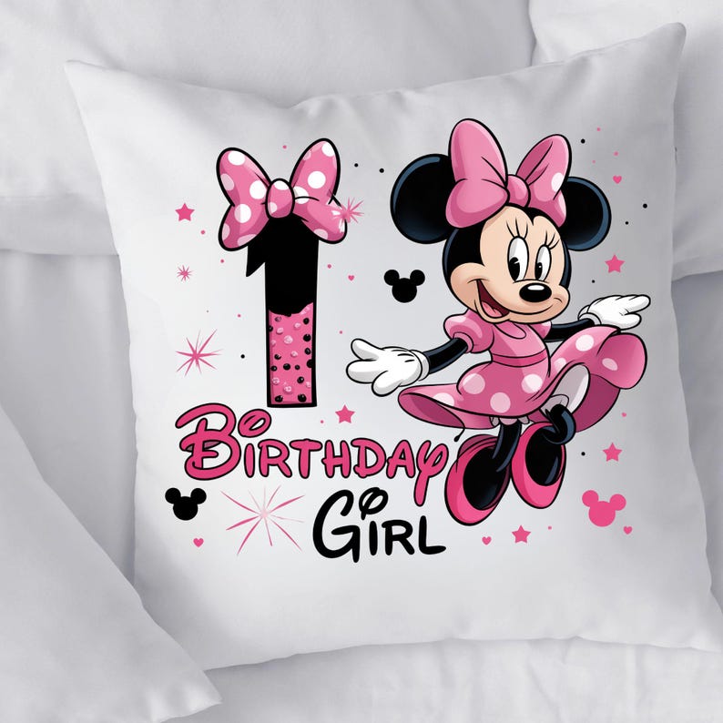 May include: White square cushion with a Minnie Mouse design. The design features a large number 1 with a pink polka dot bow, Minnie Mouse in a pink polka dot dress, and the words "Birthday Girl". Pink stars and Mickey Mouse silhouettes complete the design.