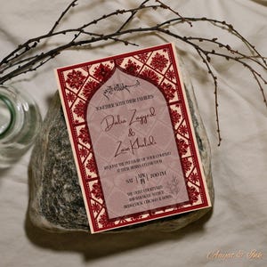 May include: A wedding invitation with a burgundy and cream color scheme. The invitation features floral and geometric patterns, with the names Dalia Zayyed & Zain Khalidi. The text includes the date, time, and location of the event.