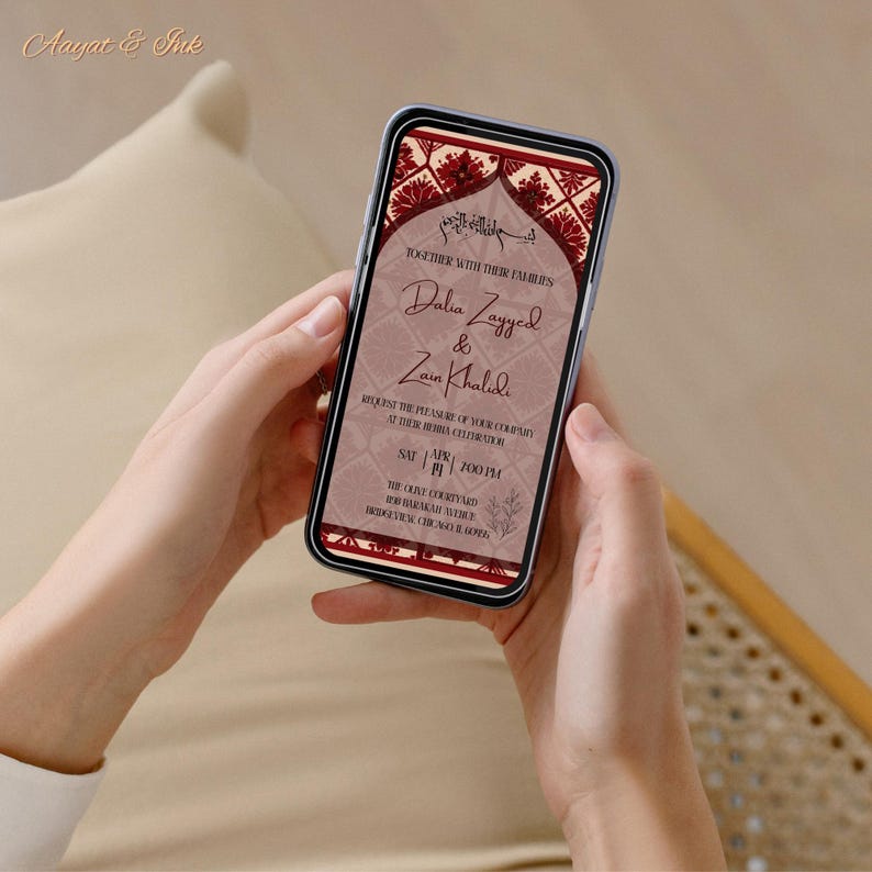 May include: A smartphone displaying a wedding invitation. The invitation features the names Dalia Zayyed & Zain Khalidi, with decorative floral and geometric patterns in burgundy and cream. The phone is held in two hands.