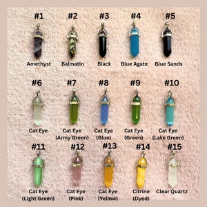 May include: Fifteen gemstone pendants in a range of colours, including amethyst, black, blue, green, and yellow. Each pendant has a silver-coloured metal cap and bail. The pendants are labelled with their gemstone type and a number.