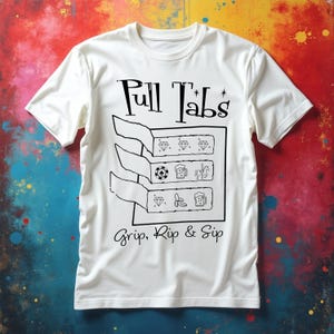 May include: White t-shirt with the text "Pull Tabs" and "Grip, Rip & Sip" in black script. The shirt features a graphic of three pull tabs with various symbols, including diamonds, a soccer ball, a beer mug, a banana, and a unicorn.