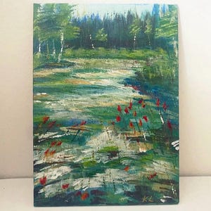 May include: An original landscape painting depicting a serene forest scene. The artwork features a vibrant green meadow with red flowers, a flowing stream, and a backdrop of lush trees. The painting is signed "KL" in the bottom right corner.