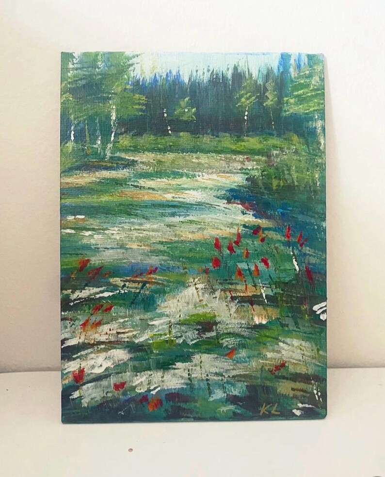 May include: An original landscape painting depicting a serene forest scene. The artwork features a vibrant green meadow with red flowers, a flowing stream, and a backdrop of lush trees. The painting is signed "KL" in the bottom right corner.