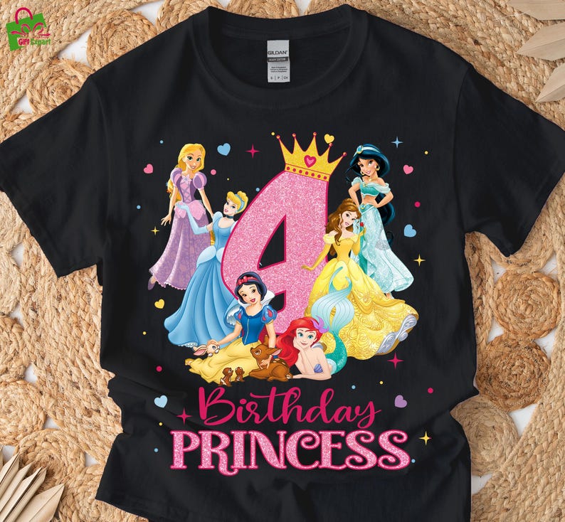 Pu&ograve; includere: T-shirt nero con grafica di principesse Disney, un grande numero 4 rosa e la scritta "Birthday PRINCESS". Le principesse indossano abiti colorati, con una corona d'oro sopra il numero.