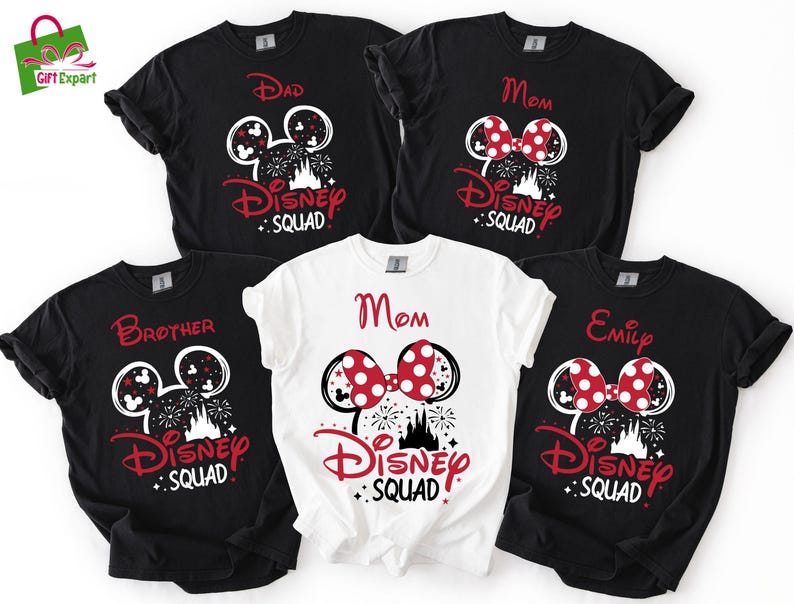 Puede incluir: Una colecci&oacute;n de camisetas negras y blancas de Disney Squad con detalles en rojo. Las camisetas presentan orejas de Mickey Mouse, fuegos artificiales y los nombres "Dad", "Mom", "Brother" y "Emily". Una camiseta blanca tambi&eacute;n dice "Mom".