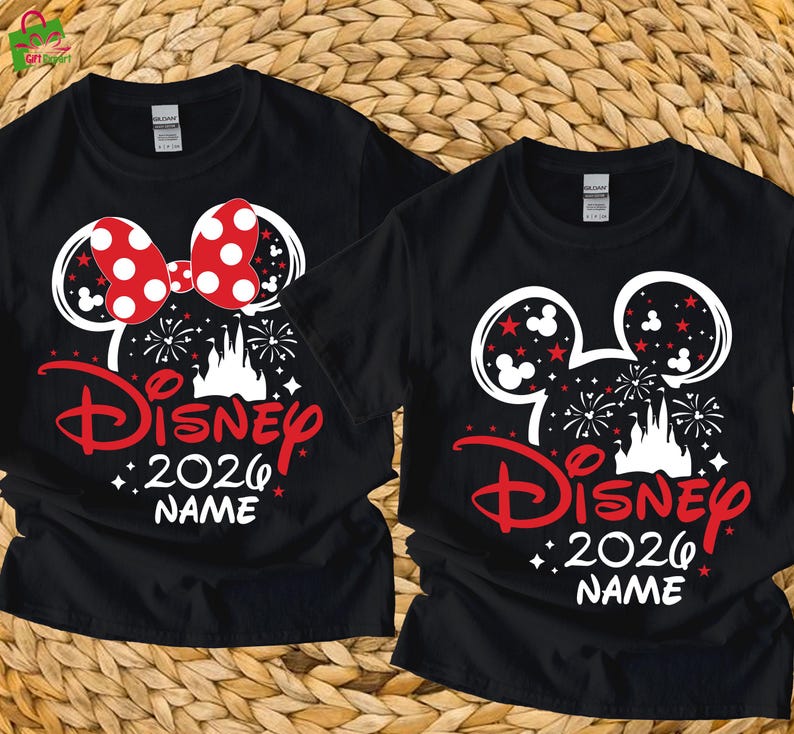 May include: Two black t-shirts with a Disney design. One features a red polka dot bow, the other has red stars. Both shirts have a white Mickey Mouse head outline, the word "Disney" in red, "2026", and space for a name.