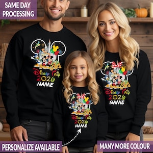 Pode incluir: Camisolas pretas com tema Disney. Cada camisola apresenta um contorno da cabe&ccedil;a do Mickey Mouse com personagens da Disney, fogos de artif&iacute;cio e o texto "Disney Trip 2026 NAME". O texto "SAME DAY PROCESSING" e "PERSONALIZE AVAILABLE" tamb&eacute;m s&atilde;o vis&iacute;veis.