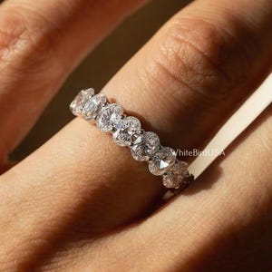 May include: A white ceramic mug with a black handle and the text "But First, Coffee" in a handwritten style. The mug is on a white surface. The mug is 4 inches tall.