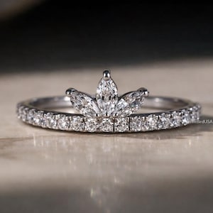 May include: A white ceramic mug with a black handle and the text "But First, Coffee" in a black, handwritten-style font. The mug is on a white surface.