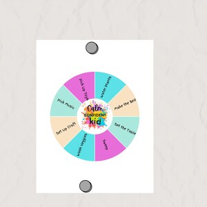 May include: A white circular chart with colorful segments, featuring tasks like "Pick Up Toys" and "Make the Bed." The center displays "Calm Confident Kid" in a vibrant splash of colors. Two gray magnets are at the top and bottom.