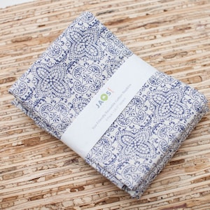 May include: A set of blue and white cotton napkins with a paisley pattern. The napkins are folded and packaged with a label that reads "Eco-friendly Reusable Cotton Napkins 6 pack 18" x 18"  JAQS".