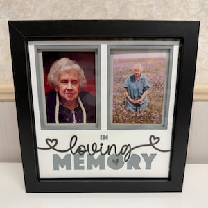Puede incluir: Marco de fotos conmemorativo negro con dos imágenes de una anciana. Las palabras "In Loving Memory" se muestran en escritura gris y negra. El marco está sobre una superficie blanca.