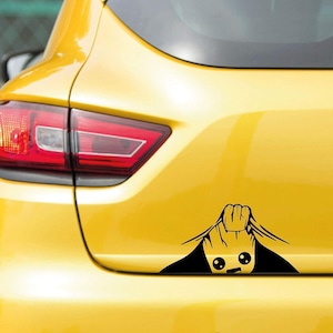 May include: A yellow car with a black decal of a cartoon character peeking out from behind the car's body. The decal features a smiling face and a hand pulling back the car's surface.