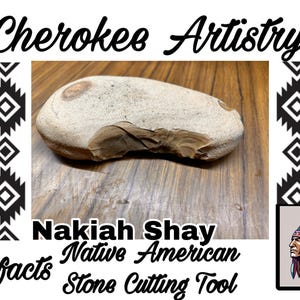 May include: A stone cutting tool, likely Native American, is displayed. The tool is a light beige color with a chipped edge, resting on a wooden surface. The image includes the text "Cherokee Artistry" and "Nakiah Shay".