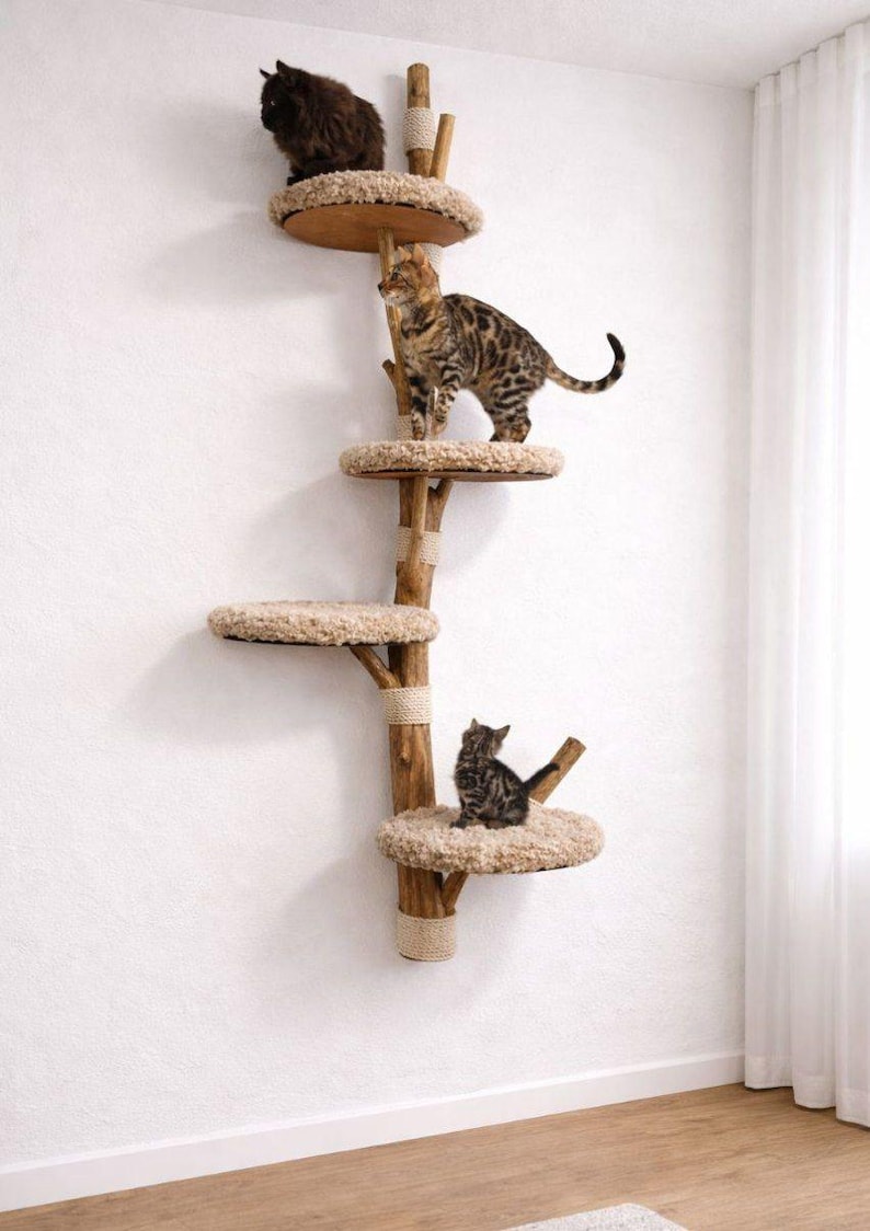 May include: A multi-level cat tree made of natural wood, featuring several circular platforms with plush, beige bedding. Three cats are perched on the tree, with one at the top, one in the middle, and one at the bottom.