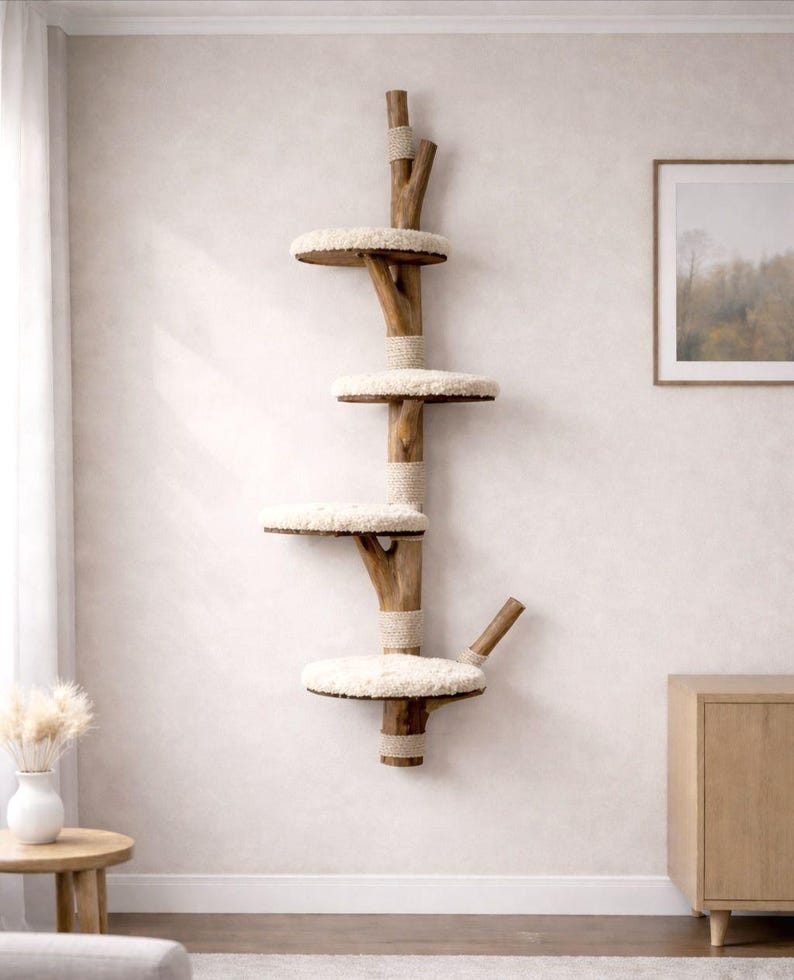 May include: A wall-mounted cat tree with four platforms. The tree is made of natural wood and features round, cream-colored, plush platforms. The central support is wrapped with rope. The cat tree is designed to provide a climbing and resting space for cats.