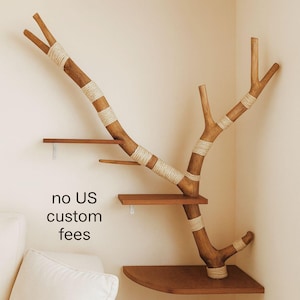 Può includere: Un albero per gatti in legno con più piattaforme e un design a forma di ramo. L'albero è realizzato in legno naturale con dettagli in corda e include il testo "no US custom fees". Le piattaforme sono di varie dimensioni e forme.