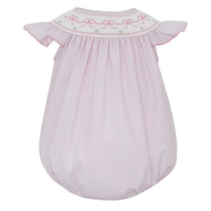 May include: A pink and white striped baby bubble with a round neckline and ruffled sleeves. The neckline is adorned with embroidered bows and green accents. The bubble has a gathered, rounded bottom.