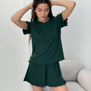 Könnte beinhalten: Rustikales Holzschild mit dem weißen Schriftzug "Welcome to our home". Das Schild hat eine Used-Optik und ein schlichtes, einladendes Design, perfekt für den Eingangsbereich.