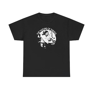 May include: Black t-shirt featuring a white circular graphic with the text "THE NATURE OF THINGS". The graphic depicts a black and white image of a person. The t-shirt is made of a soft, comfortable material.