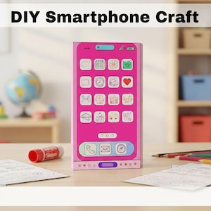 Puede incluir: Un teléfono inteligente rosa de bricolaje con iconos de aplicaciones en la pantalla. El texto "DIY Smartphone Craft" está en la parte superior. Un pegamento en barra y lápices de colores están sobre la mesa. El fondo incluye un globo terráqueo y estantes con juguetes.