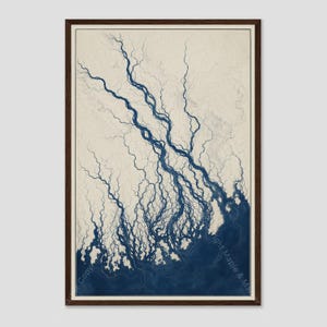 May include: A framed wall art print featuring a high-contrast map of a river delta. The design displays intricate, branching dark blue waterways flowing into a solid dark blue body of water against a light cream background with subtle contour lines.