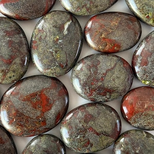 May include: A collection of polished stones with a mix of colors. The stones are primarily oval-shaped, with a smooth, glossy surface. The colors include deep reds, greens, and browns, creating a natural, earthy aesthetic. These stones are ideal for meditation or decorative purposes.