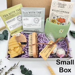 May include: A small gift box filled with tea sachets, wildflower seeds, a wooden nail brush, a bee-shaped soap, and decorative items. The box includes the text "Tea with Tae" and "Small Box".