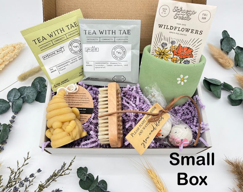 May include: A small gift box filled with tea sachets, wildflower seeds, a wooden nail brush, a bee-shaped soap, and decorative items. The box includes the text "Tea with Tae" and "Small Box".