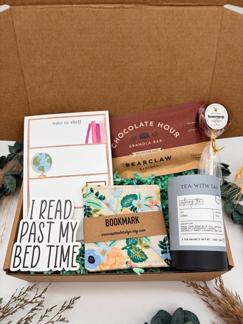Puede incluir: Una caja de regalo que contiene un bloc de notas note to shelf, una barra de granola Chocolate Hour, una paleta honeypop, un marcap&aacute;ginas de tela floral, un bote de t&eacute; Tea With Tae y una pegatina con el texto I READ PAST MY BED TIME.