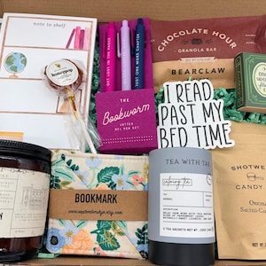 Puede incluir: Una caja de regalo que contiene un bloc de notas, una piruleta honeypop, una caja rosa con tres bol&iacute;grafos de gel, una barrita de granola Chocolate Hour, una caja verde Once Upon a Flame, una vela, un marcap&aacute;ginas floral, t&eacute; y caramelos salados.