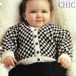 May include: A baby wearing a black and white checkered pattern cardigan with a white collar and cuffs. The cardigan has black buttons down the front. The baby is also wearing black pants. The word "CHIC" is visible in the upper right corner.
