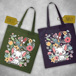 Może przedstawiać: Dwie torby, jedna w kolorze leśnej zieleni i druga w kolorze granatowym, każda z wizerunkiem świni i koguta z kresk&oacute;wek otoczonych kwiatowymi wzorami. Zielona torba ma etykietę z napisem "FOREST", a granatowa "NAVY".