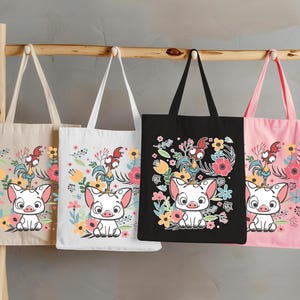 Może przedstawiać: Cztery torby w kolorze beżowym, białym, czarnym i r&oacute;żowym, każda z nadrukiem świni i koguta z kresk&oacute;wek z kwiatowymi akcentami. Torby wiszą na drewnianym drążku, prezentując kolorową grafikę.