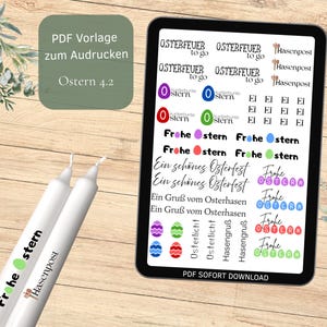 Op de afbeelding: Een digitale tablet toont Pasen-thema graphics en tekst, waaronder "Frohe Ostern" en "Hasenpost". Twee witte kaarsen met tekst staan op de voorgrond. De tablet staat op een houten oppervlak met bloemaccenten.