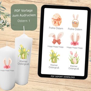 Könnte beinhalten: Weiße Stumpenkerzen mit Oster-Illustrationen und Text, neben einem Tablet mit Oster-Grafiken. Die Kerzen zeigen Hasenohren und Blumendesigns. Das Tablet zeigt verschiedene Osterei- und Hasen-Grafiken.