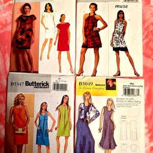 May include: Collection of Butterick sewing pattern envelopes featuring illustrations of dresses. The patterns showcase various dress styles, including a red floral print dress, a white dress with pockets, and a halter dress with a floral pattern. The envelopes are on a pink tie-dye background.
