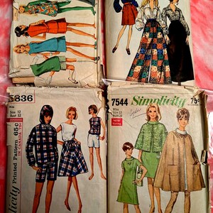 May include: A collection of vintage Simplicity sewing patterns. The patterns feature illustrations of women's clothing designs from the mid-20th century, including dresses, skirts, and pants. The patterns are in various sizes and styles.