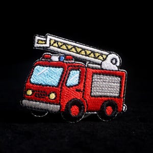 May include: Embroidered patch of a red fire engine with a white and yellow extending ladder. The fire engine has blue windows, grey accents, and black wheels. A fun patch for children or anyone who loves fire engines.