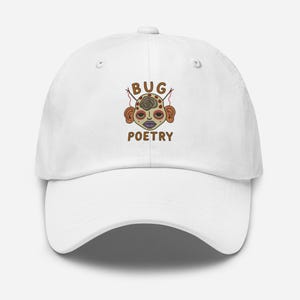 May include: White baseball cap with a curved brim. The cap features an embroidered design of a face with the words "BUG POETRY" in brown. The face has a spiral design on the forehead, with brown ears and red accents.